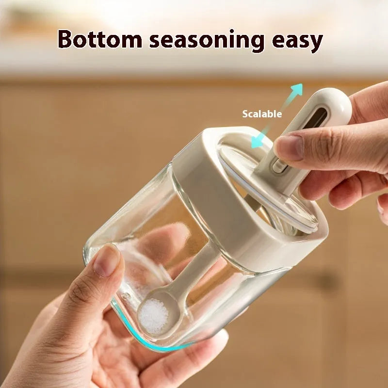 Retractable glass seasoning jar in Nordic style with green lid, showing clear glass body and dispensing mechanism