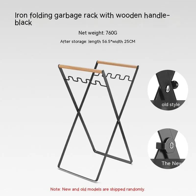 Foldable black wrought iron garbage storage hanger with a wooden handle, shown holding a bin bag.