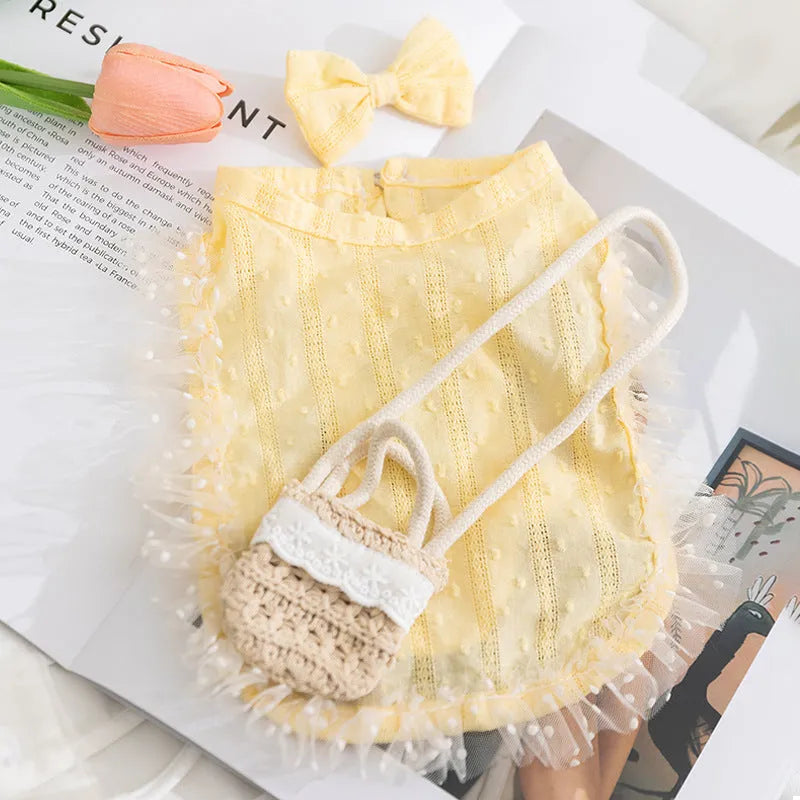 Small dog wearing yellow two-tone country shoulder bag outfit with matching bow and woven crossbody bag