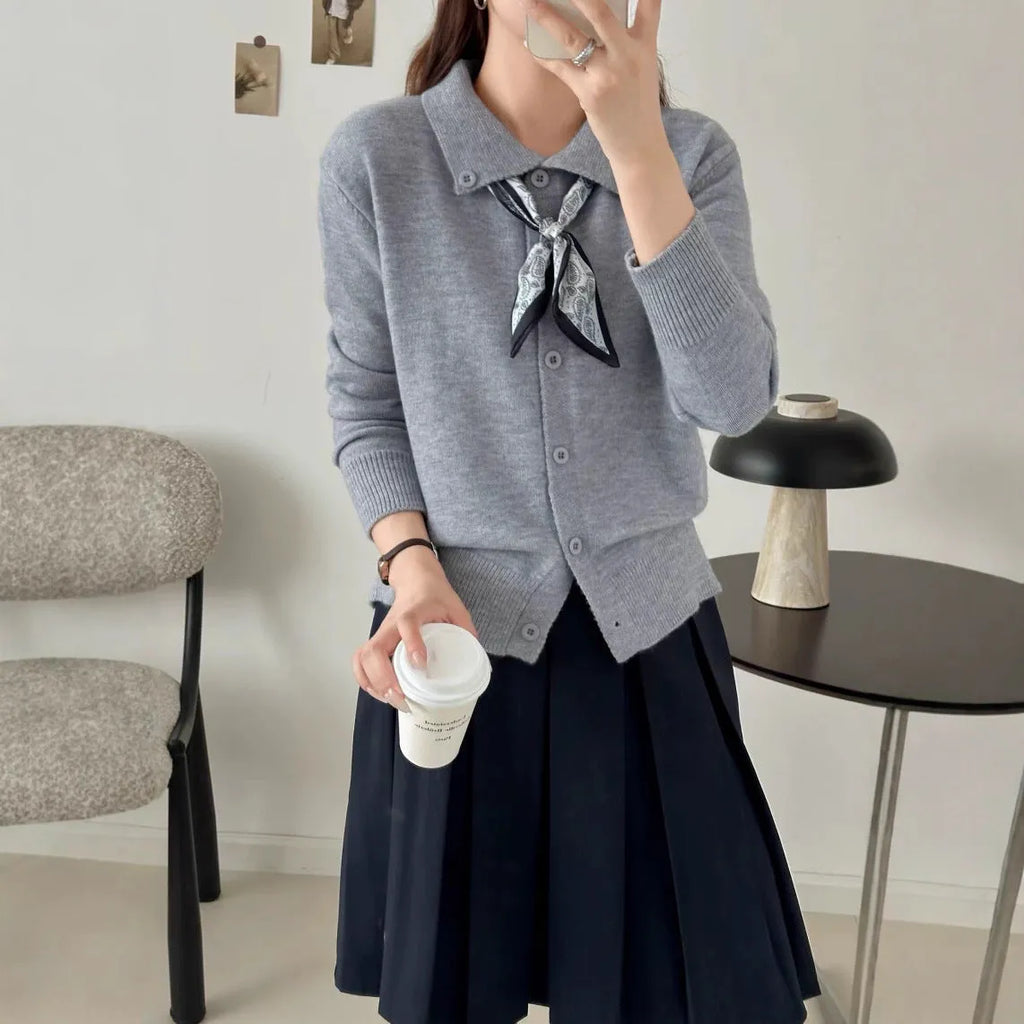 Milky white acrylic cardigan sweater with lapel collar and scarf trim detail, long sleeves.