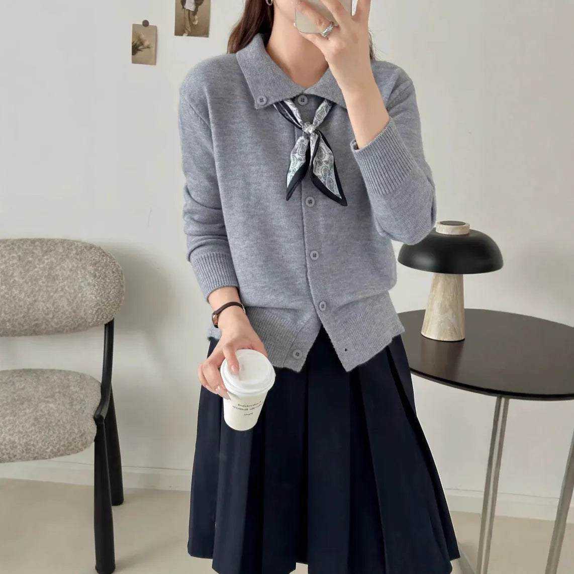 Milky white acrylic cardigan sweater with lapel collar and scarf trim detail, long sleeves.