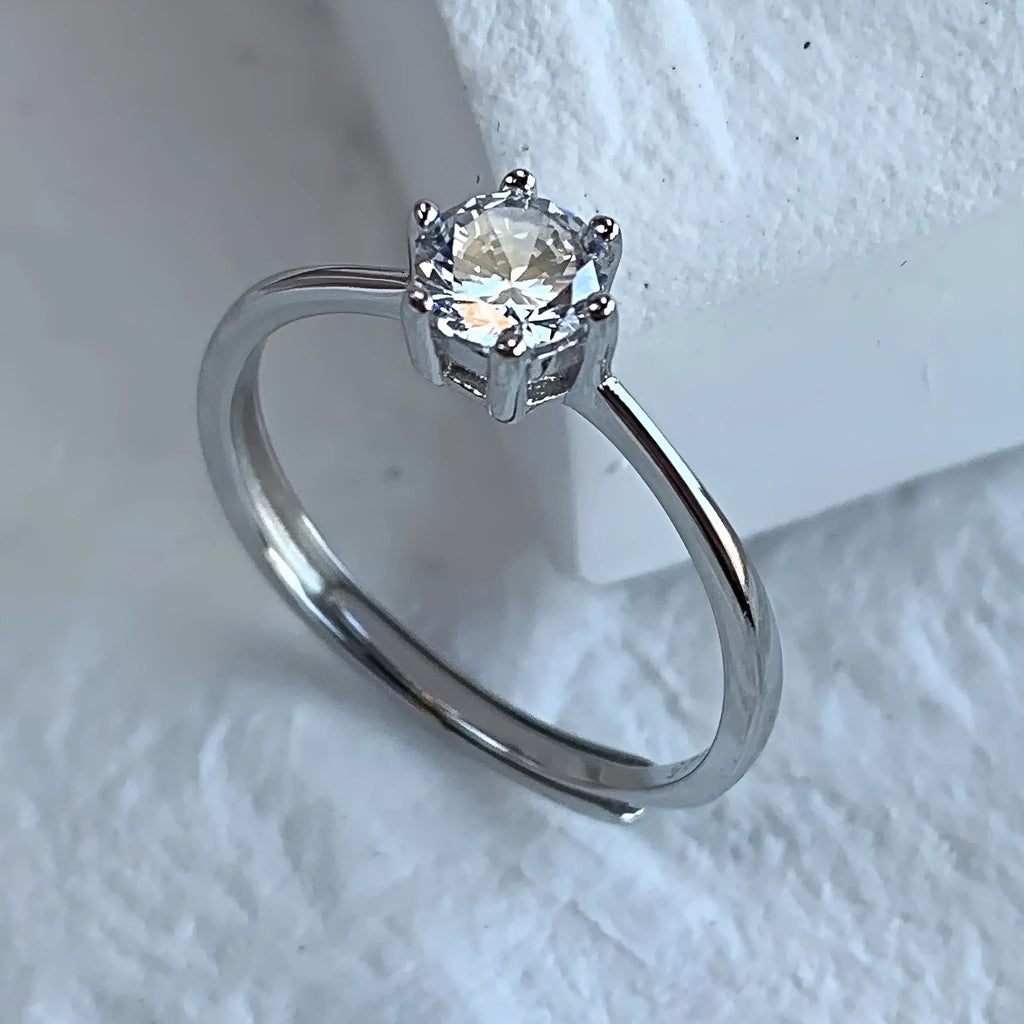 Sterling silver ring with six-claw zircon setting and open mouth adjustable band on white background