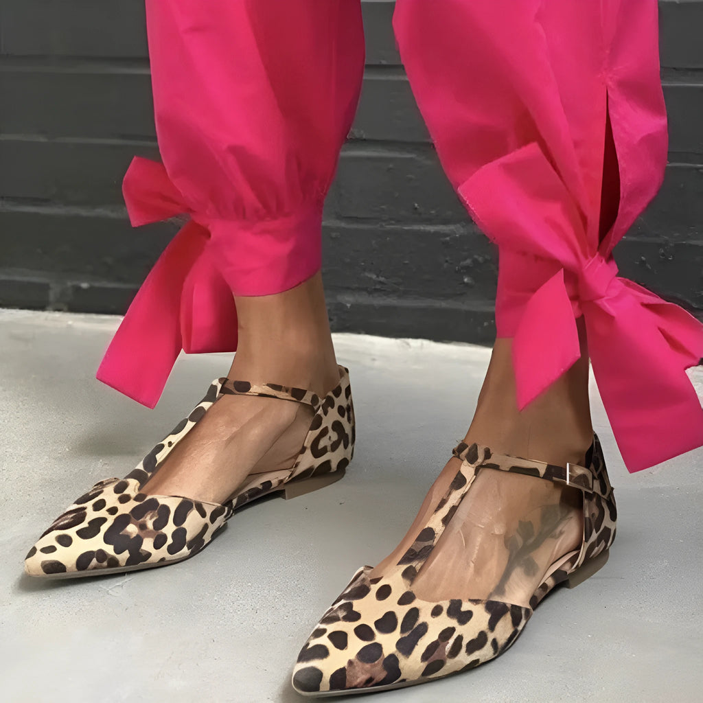 Leopard print women's pointed toe pumps with a cross strap and a low chunky heel.