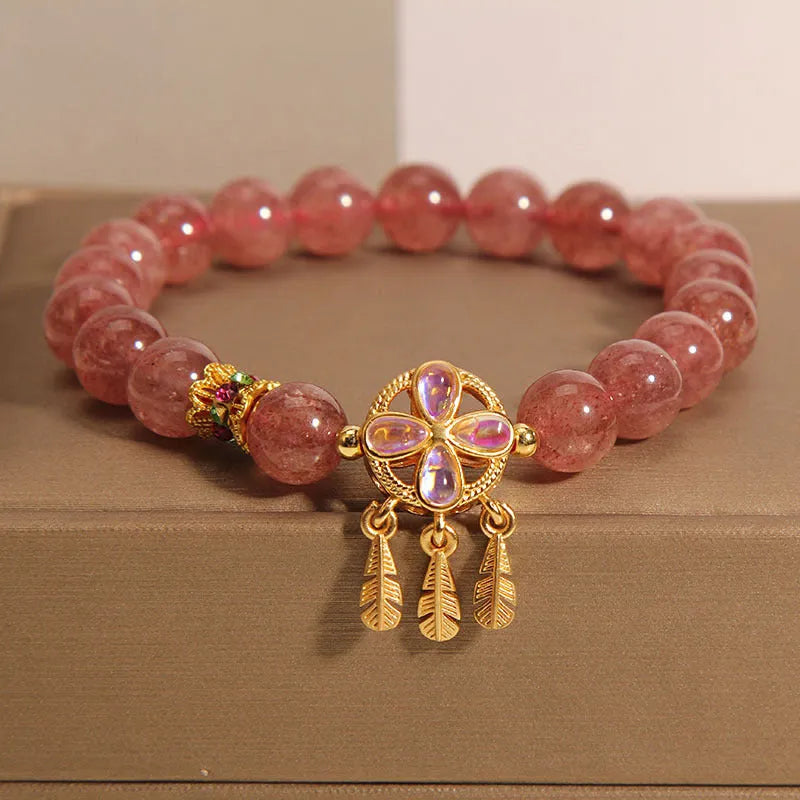 Natural strawberry quartz bracelet for women with a four-leaf dream catcher ball pendant on an elastic cord.