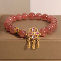 Natural strawberry quartz bracelet for women with a four-leaf dream catcher ball pendant on an elastic cord.