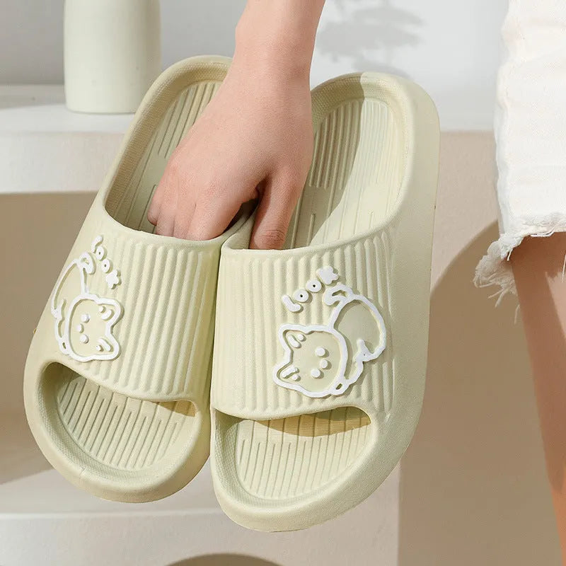 Women's green cat slippers with thick platform sole and flip-flop design on a white background.