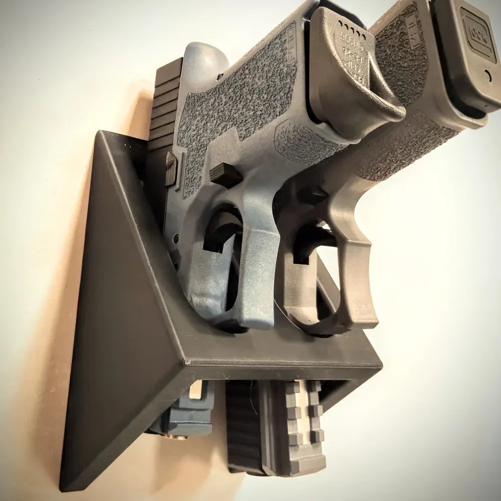 Black punk-style plastic pistol display stand on a flat surface.