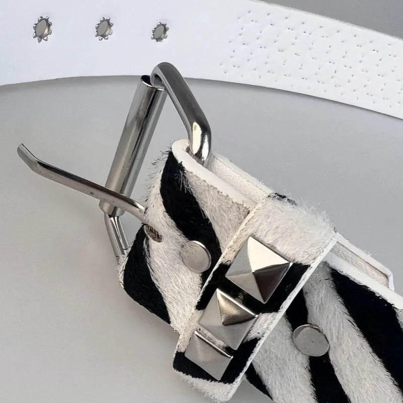 Punk women's belt with metal pyramid rivets in animal print patterns, showing pin buckle fastening