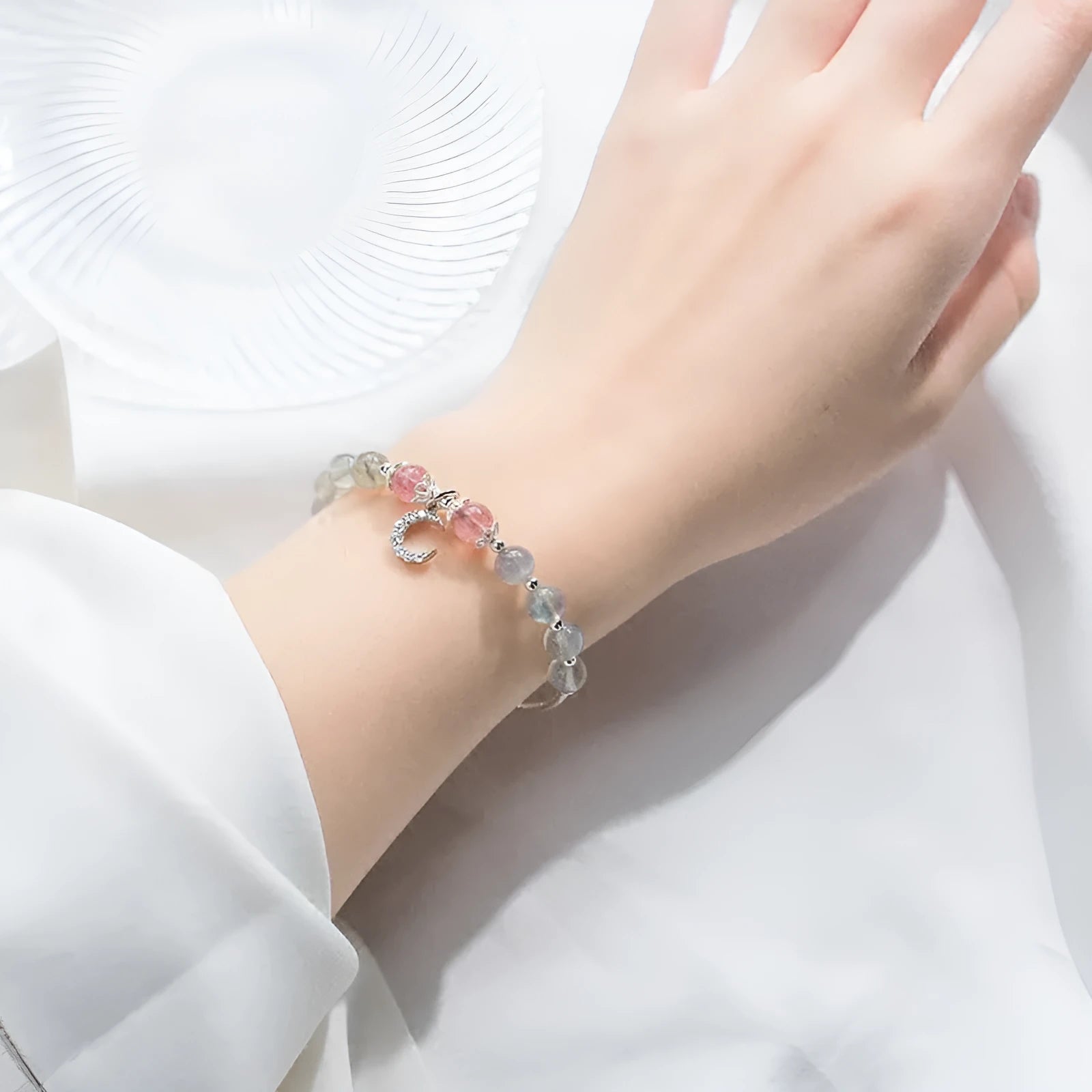 Handmade adjustable moonstone bracelet with crescent moon charm and crystal pendant on wrist