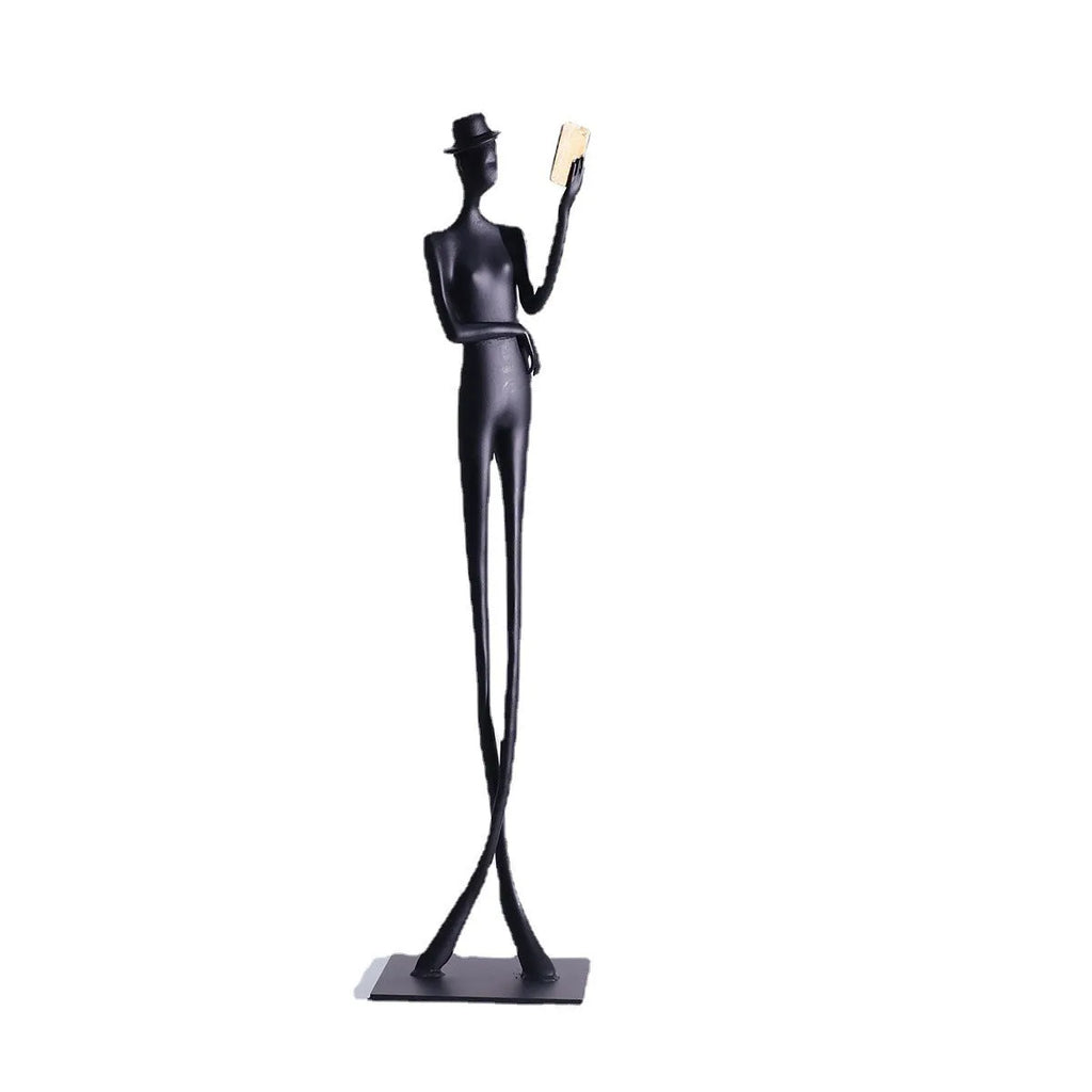Black metal sculpture of a woman reading, modern aluminium desktop ornament.