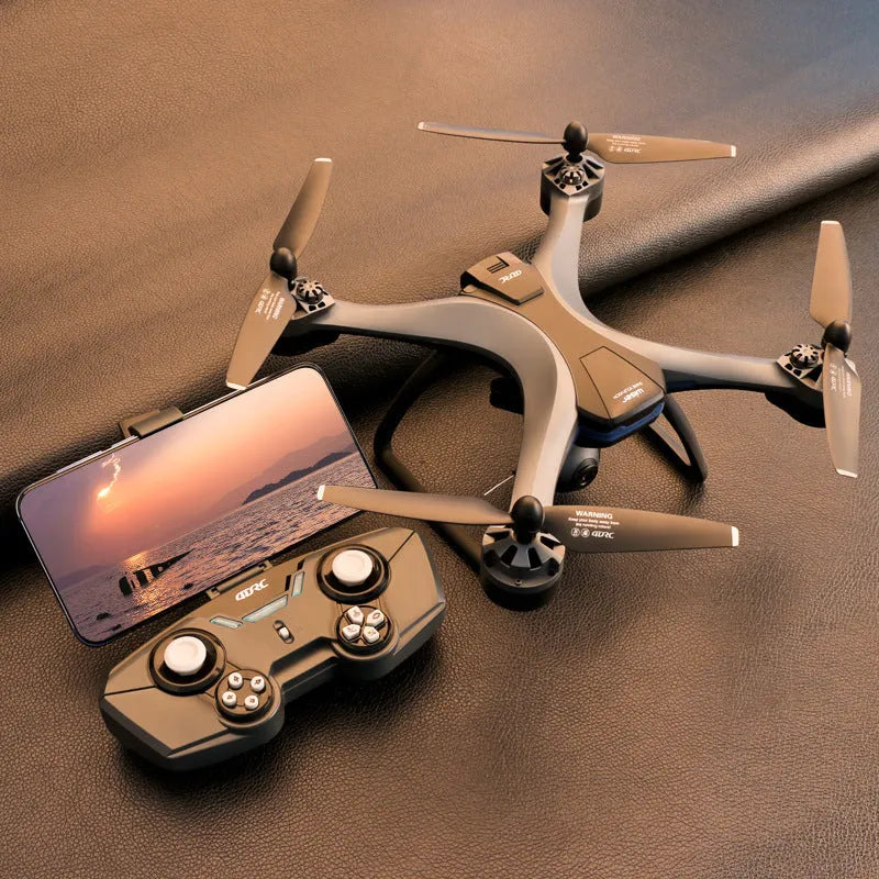 Plastic quadrocopter drone with four rotors, a handheld remote controller, and spare fan blades on a landing gear.