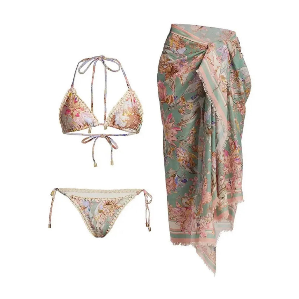 Women's creamy white floral bikini set with top, briefs, and matching skirt on a mannequin.