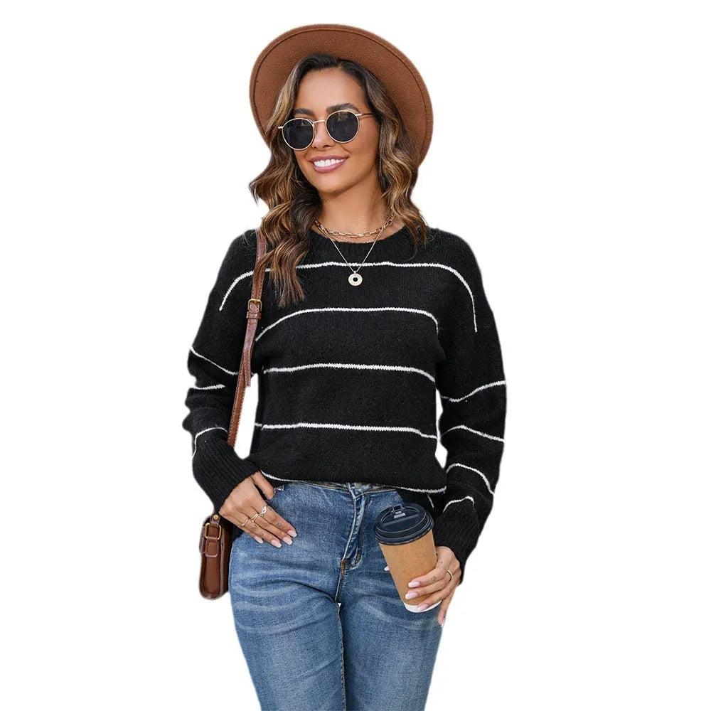 Women's black and white striped loose-fit pullover sweater with round neck.