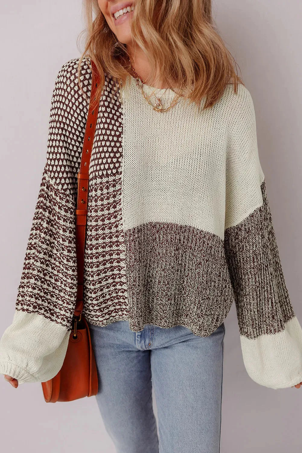 Dark khaki loose sweater with colour block design and back tie, on a model.