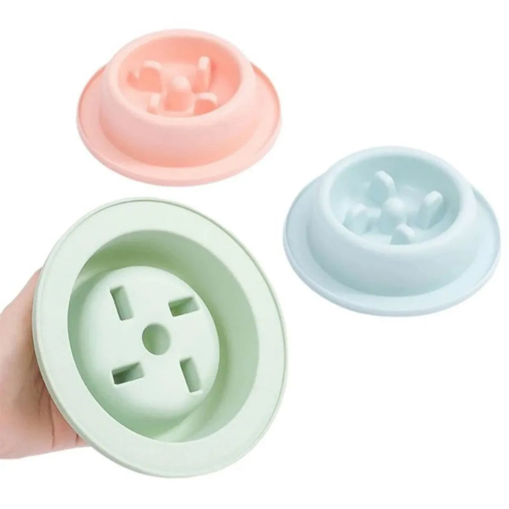 Pink pet slow feeder bowl with raised maze pattern and non-slip base on a floor