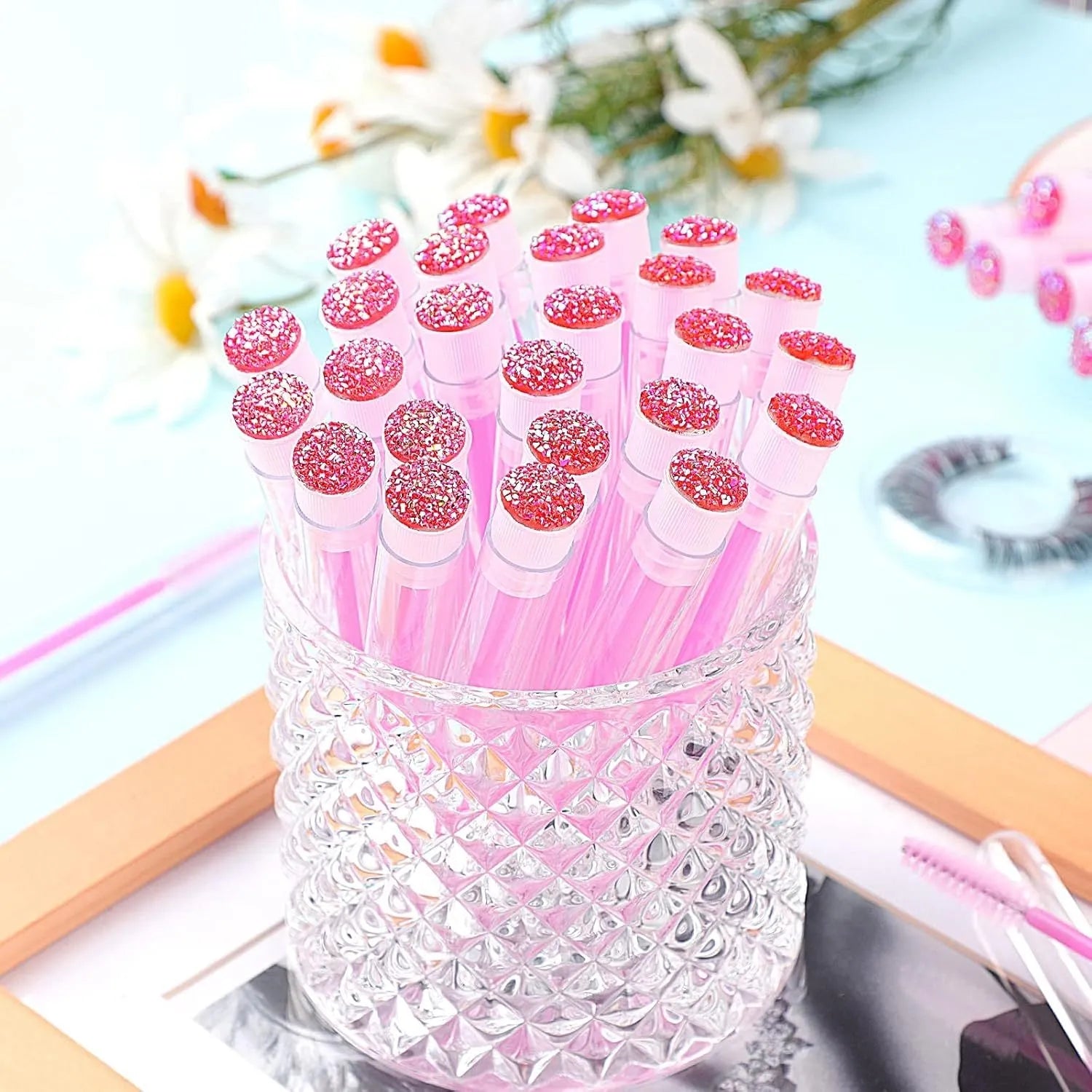Set of coloured disposable eyelash brushes stored in clear plastic tubes
