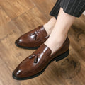 Men's black and brown slip-on business casual shoes with tassel detail and rubber sole.