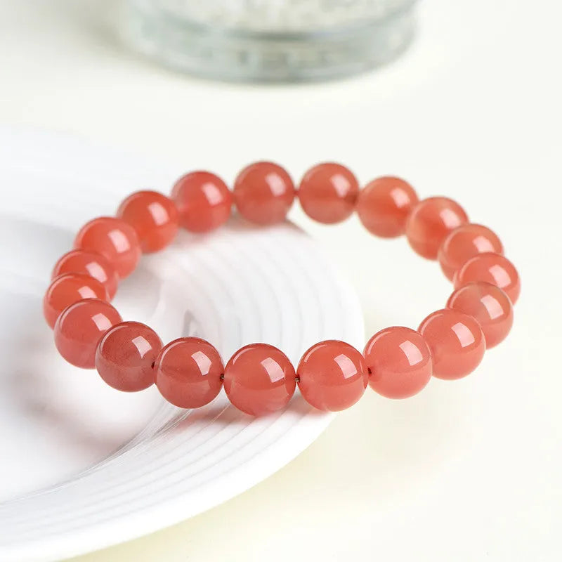 Natural cherry red agate beaded bracelet with polished round stones on a string.
