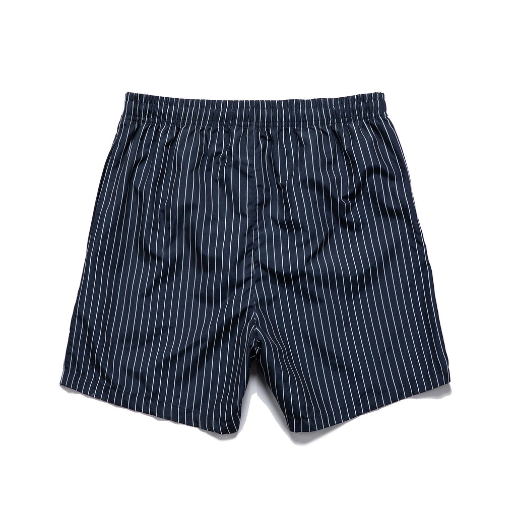 A pair of striped beach shorts in a light blue colour with a straight leg opening, laid flat.