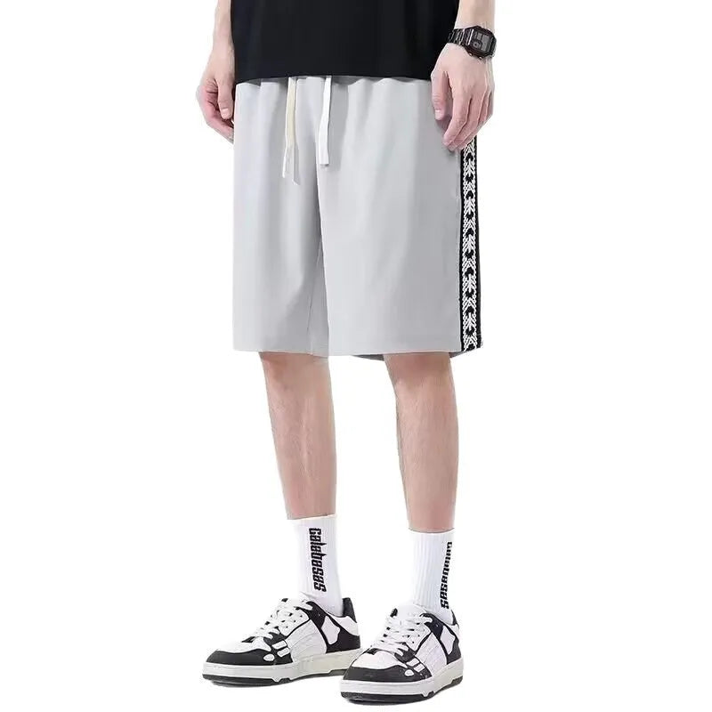 Man wearing loose black track pants with a sporty style, showing the baggy fit and micro elastic fabric.