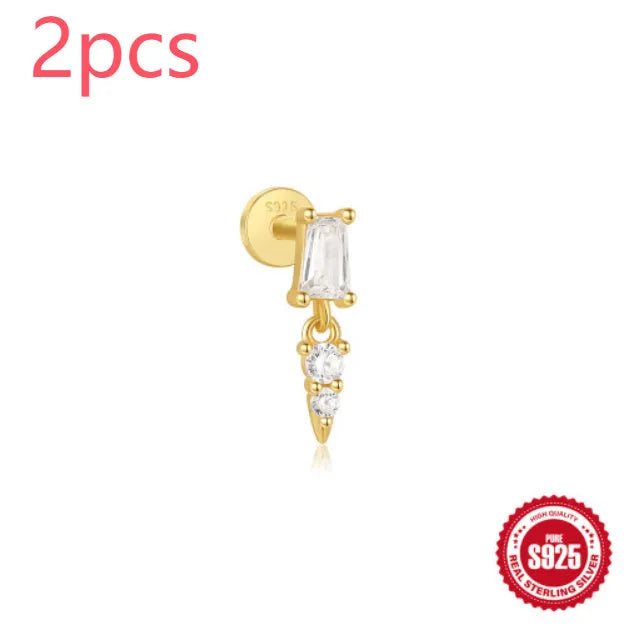A gold tone sterling silver ear stud featuring a dangling tassel and XINGX inlaid design on the stud.