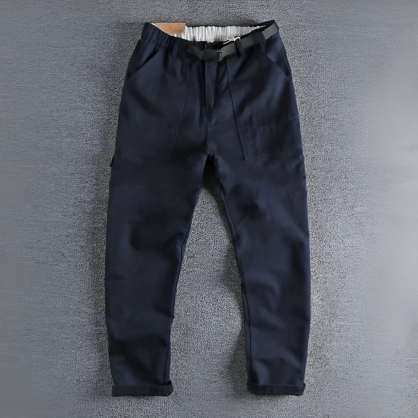 Men's khaki cotton work trousers with a buckle belt and three-dimensional cut on a hanger.