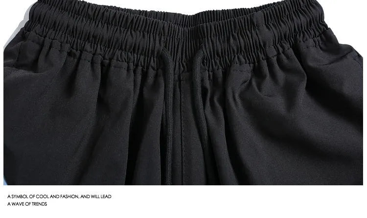 Man wearing loose-fitting black quick-dry sports shorts with an elastic waist for training.
