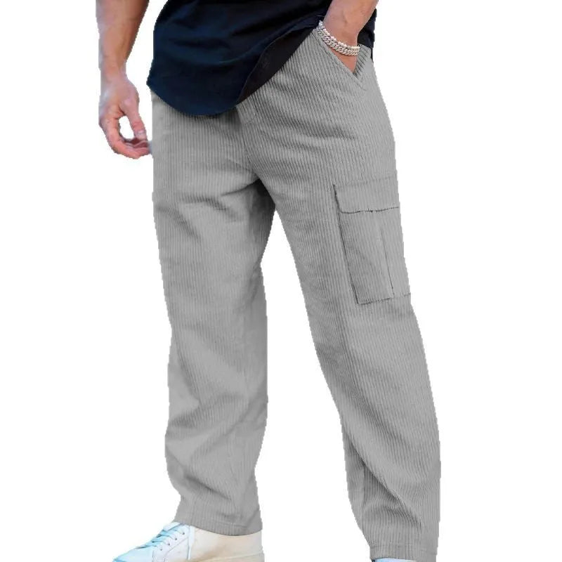 Man wearing loose-fitting straight-leg corduroy cargo trousers in navy blue with a drawstring waist.