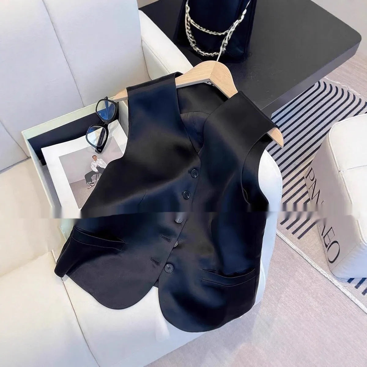 Black satin ladies sleeveless vest with loose fit on hanger