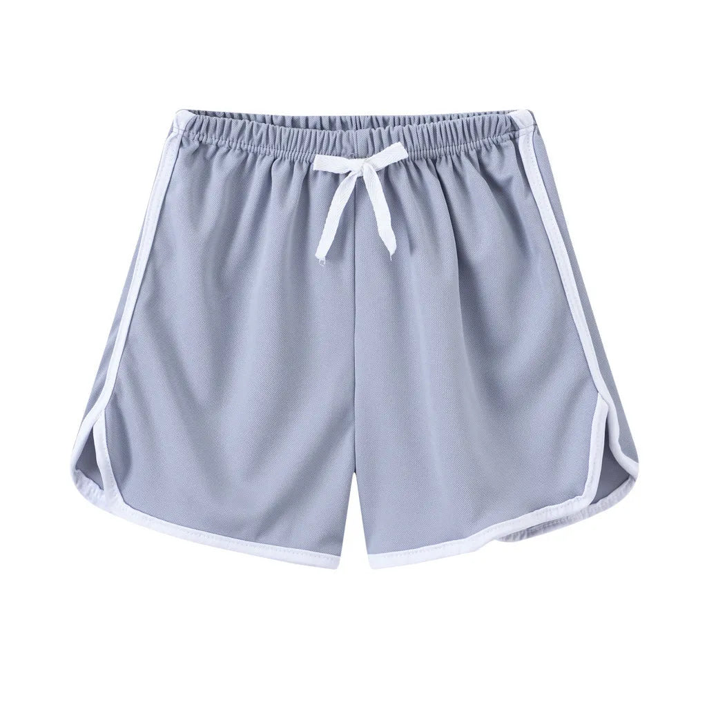 Children's polyester holiday shorts in multiple colours and patterns including stripes, leopard print, and pineapple design.