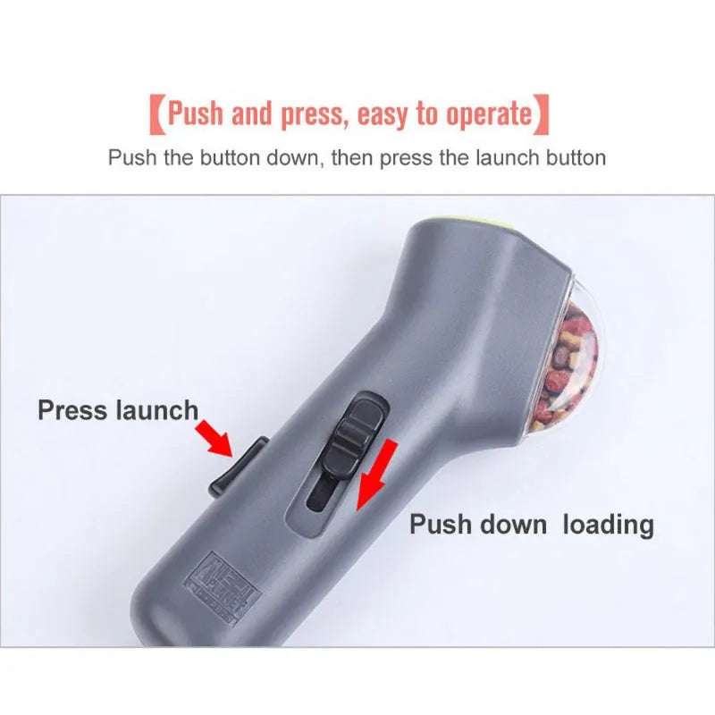 Grey compact pet snack catapult launcher on a plain background, showing the handle and trigger mechanism.