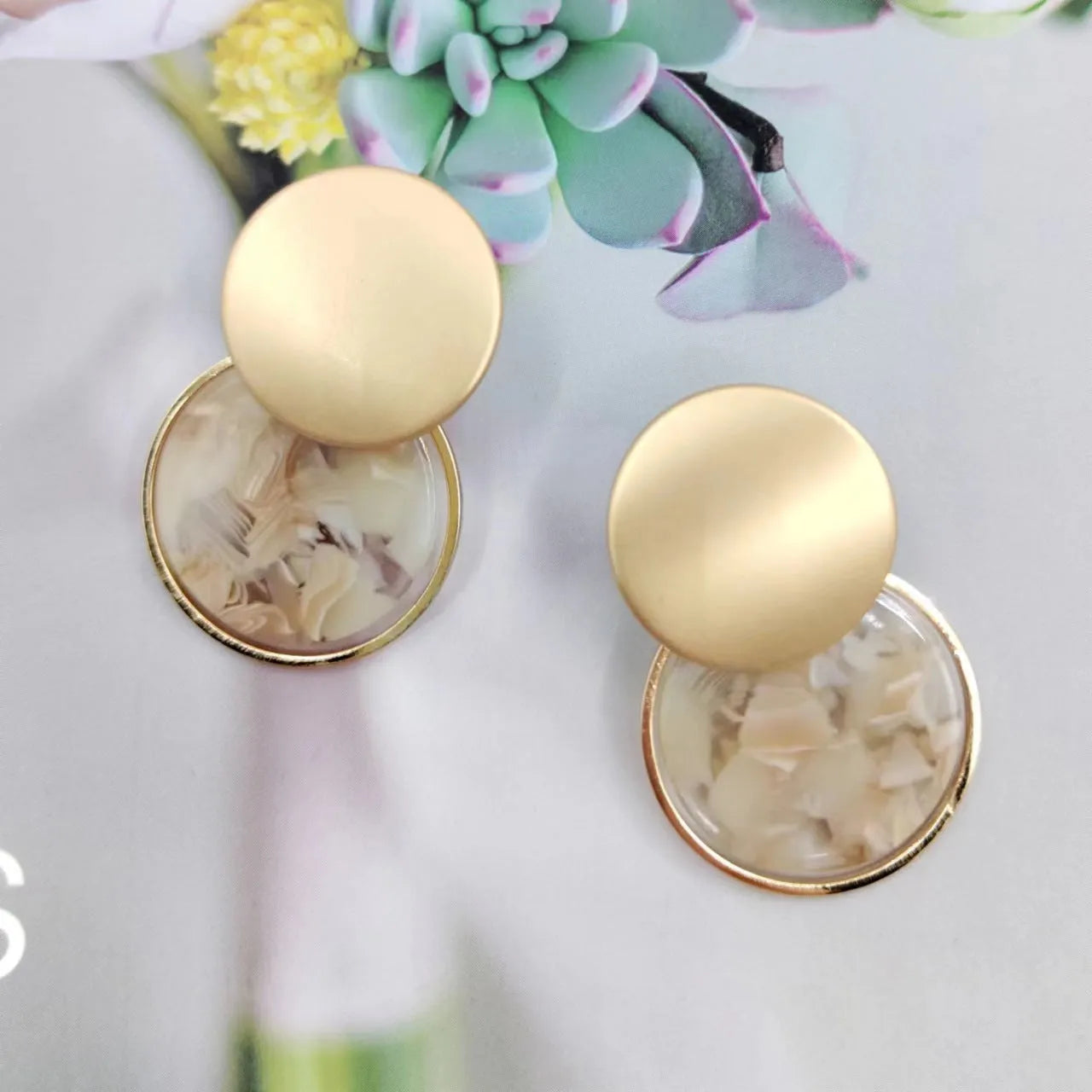 Retro personalized round matte resin female earrings with rotundity shape on a neutral background