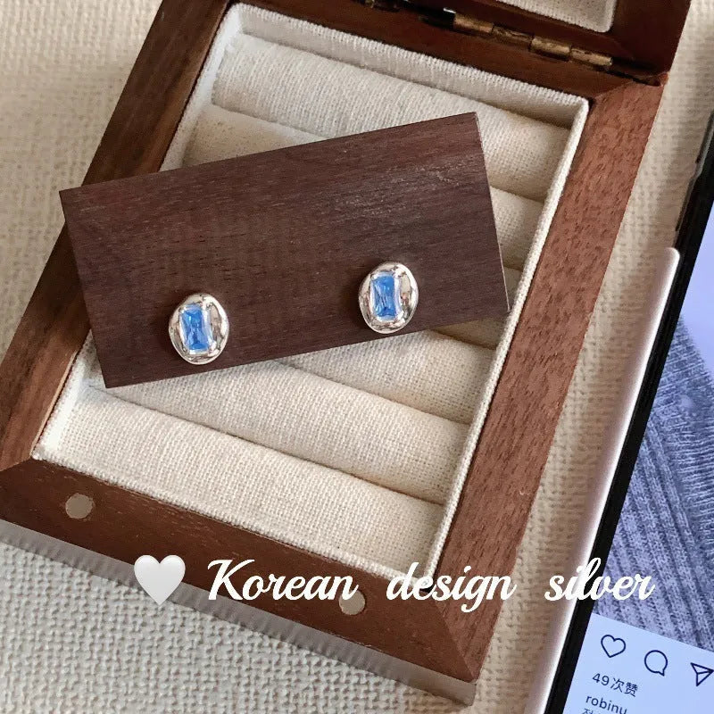 S925 sterling silver oval earrings with heart-wrapped blue diamond design in silver colour