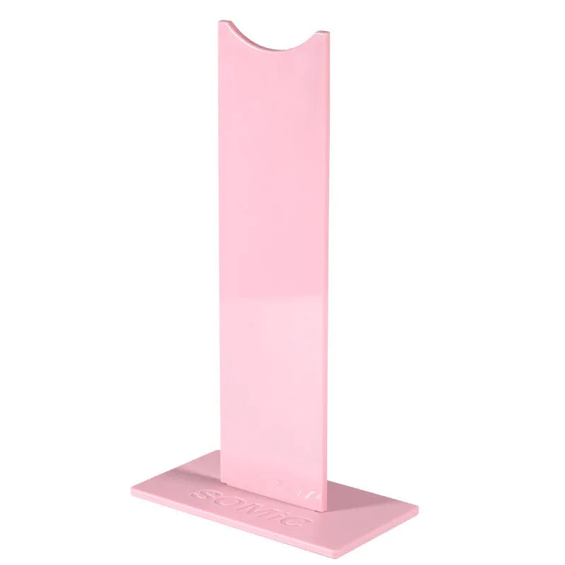 Pink and black detachable headphone stand for gaming headsets on a desk