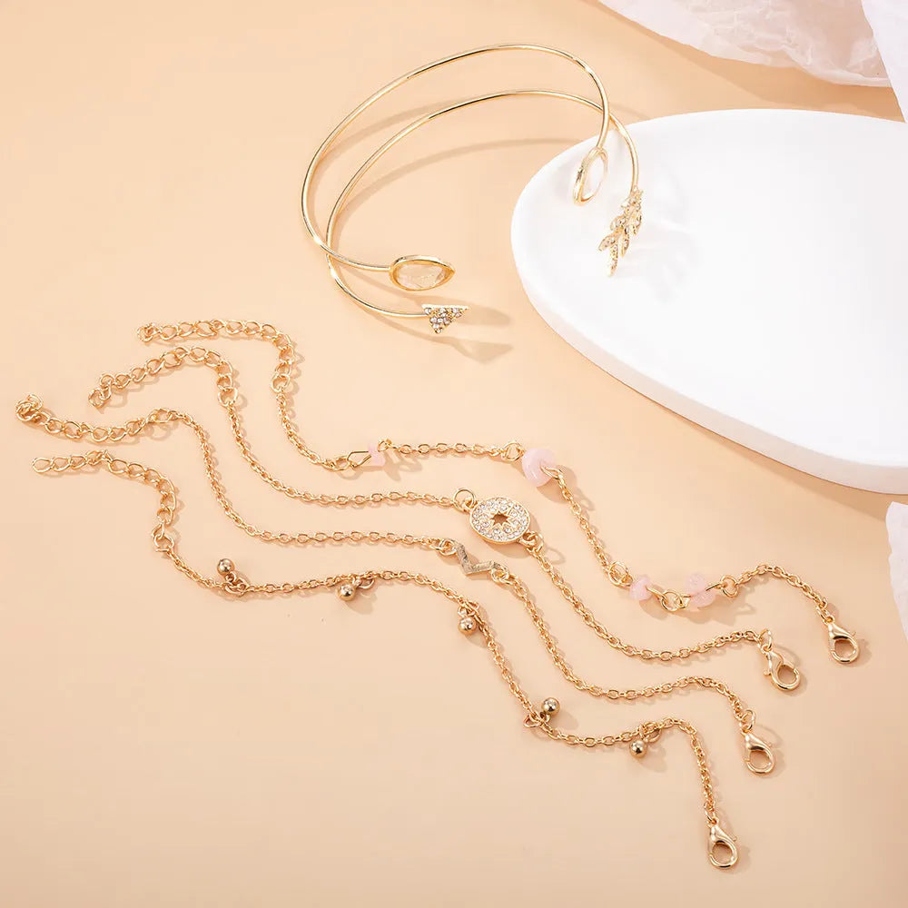 Gold zinc alloy bracelet set with six pieces showing arrow and water drop charms