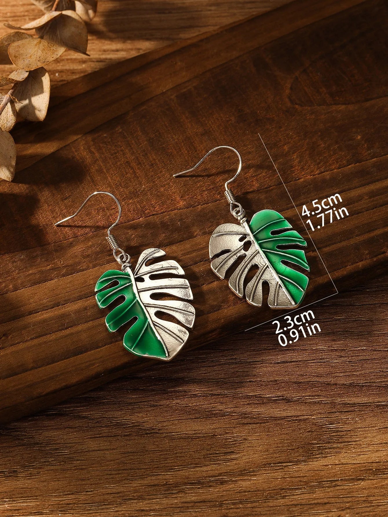 Silver alloy leaf-shaped drop earrings for women on white background