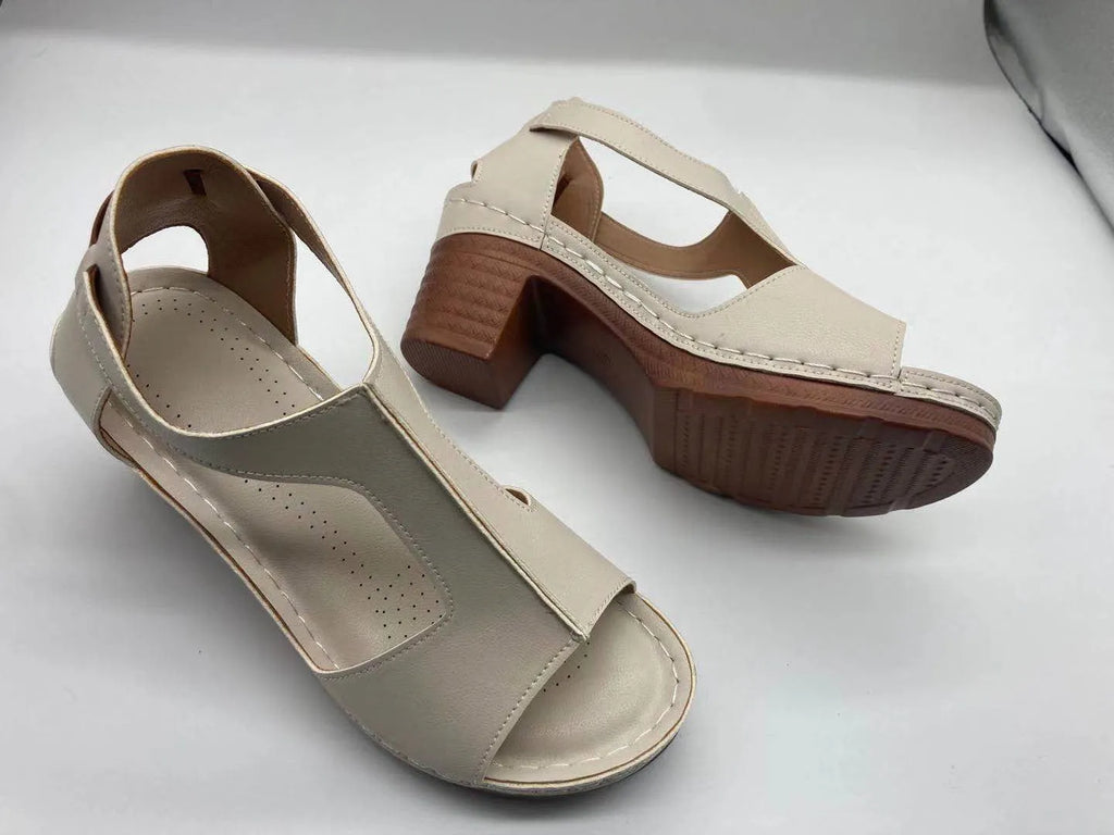 Women's beige peep toe wedge sandals with ankle buckle, shown on a foot.