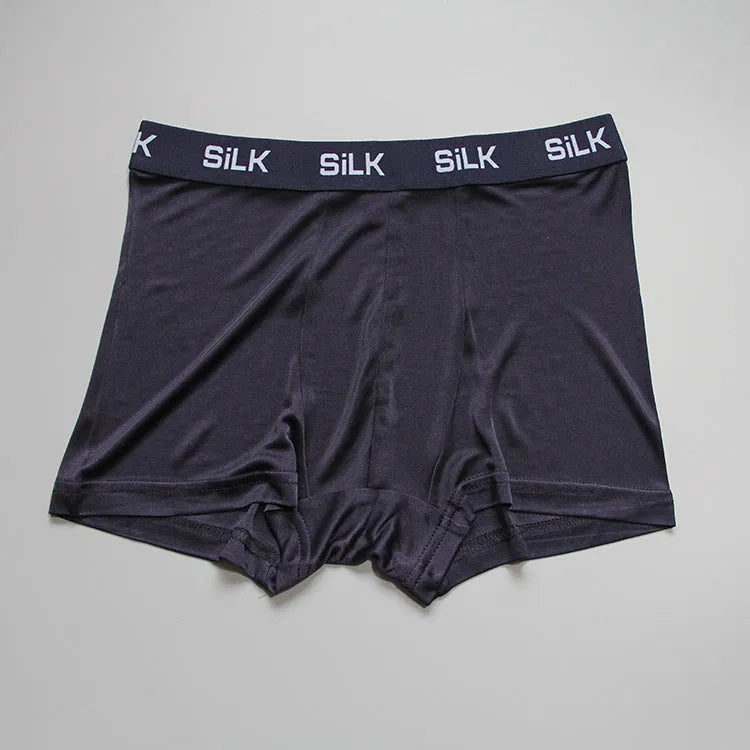 Men's loose navy blue silk shorts with a mid-waist design on a neutral background