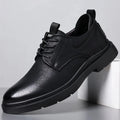 Men's black and brown leather casual sneakers with sewing line detail on the cowhide upper and a rubber sole.