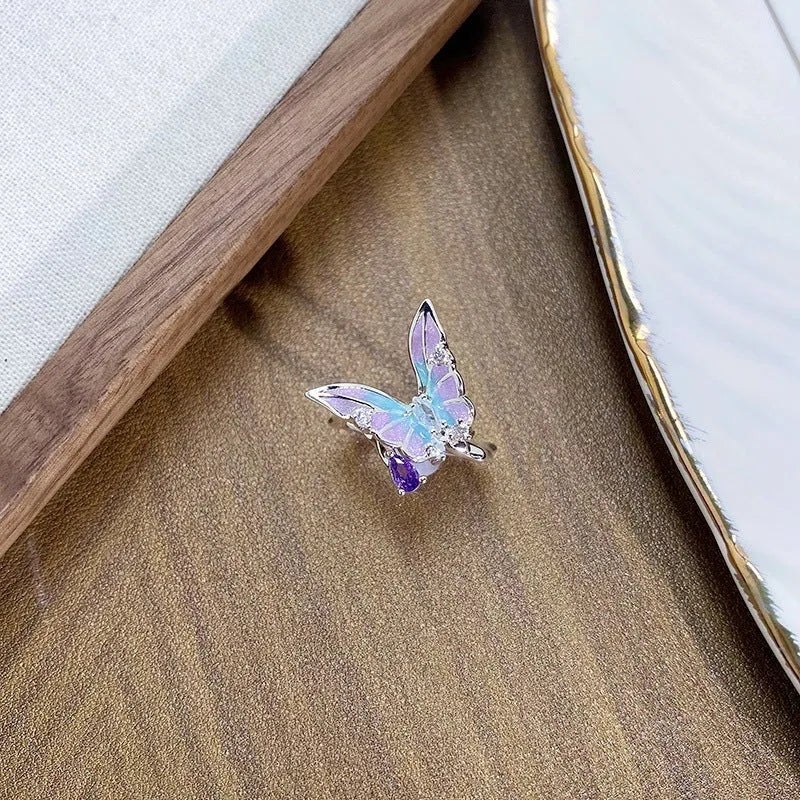 Adjustable copper insect ring with dripping oil finish in one of three colours on a hand.