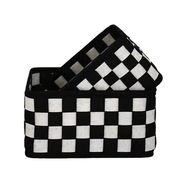 Checkerboard patterned grey felt storage basket with folded sides, shown empty.
