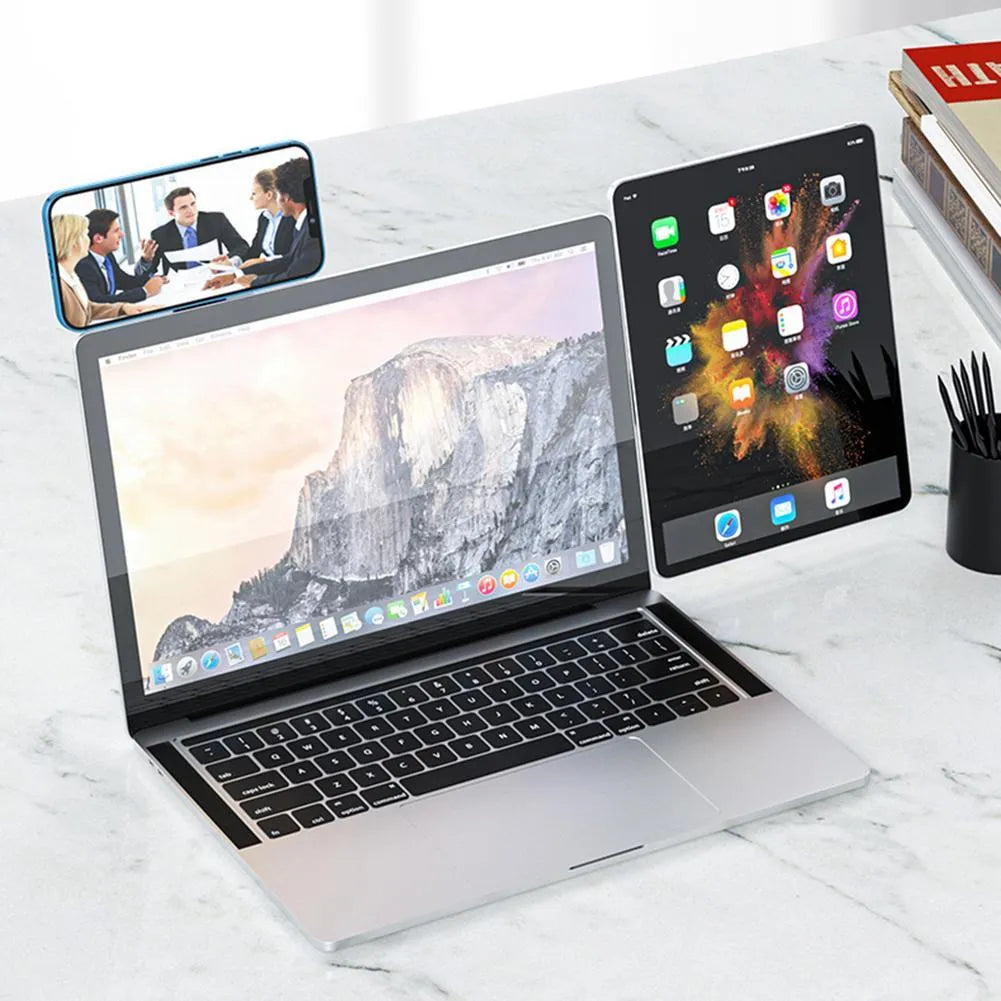 Black aluminium magnetic phone holder attached to side of silver laptop