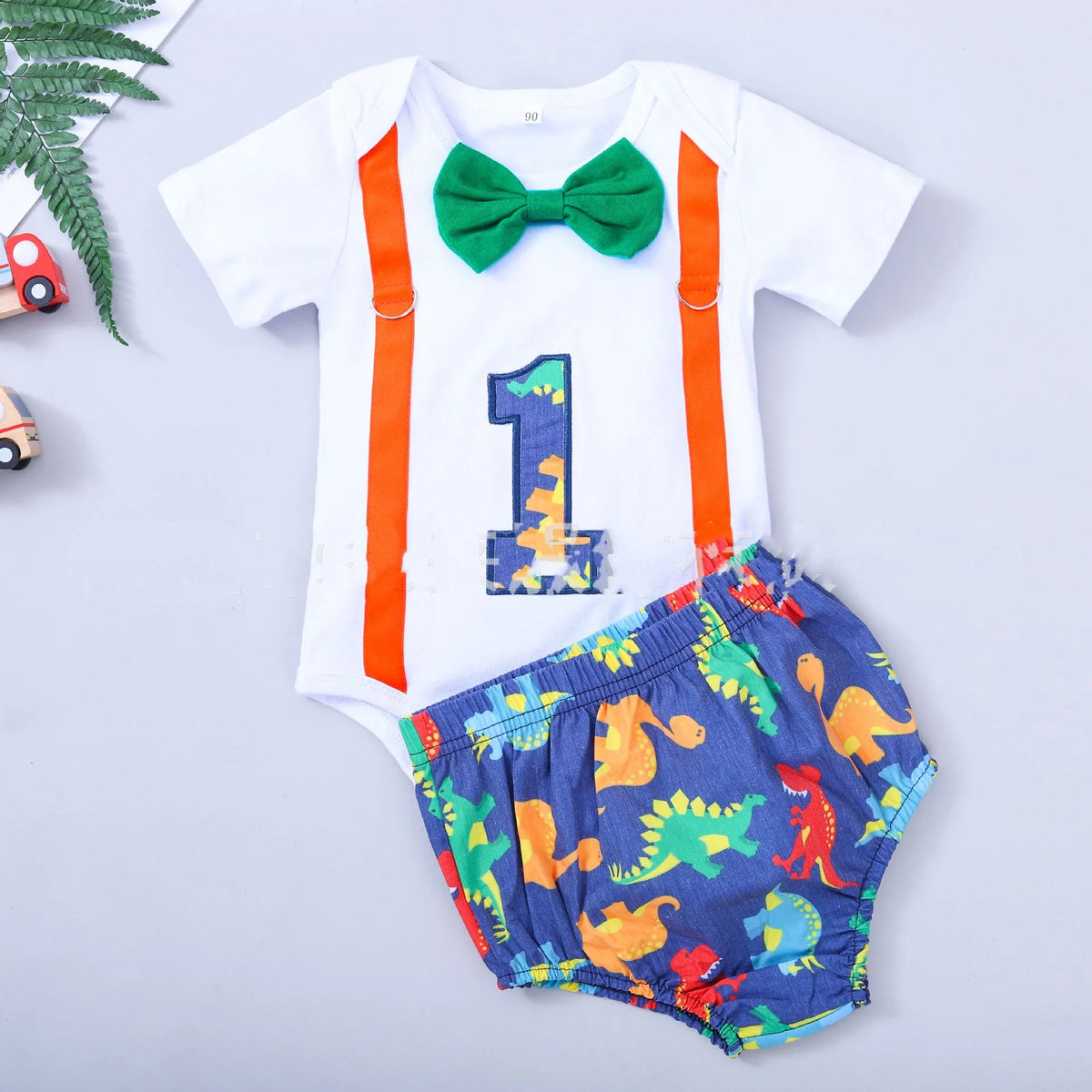 Baby in a soft cotton dinosaur print romper with shorts, showing the pullover design and clean finish.