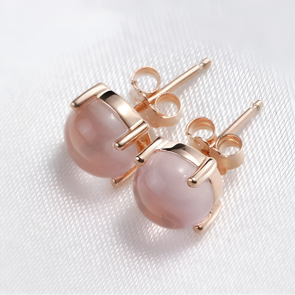 Women's rose gold plated stud earrings with a drop-shaped synthetic rose quartz stone.