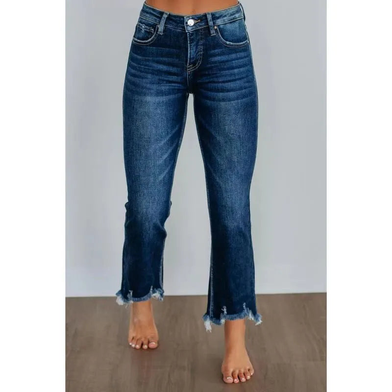 Women's dark blue denim jeans with hand-worn distressing detail on a hanger.