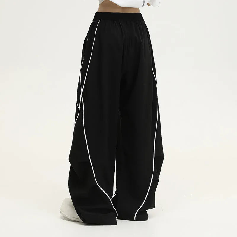 Black and grey striped men's wide-leg pleated sports pants on a hanger.