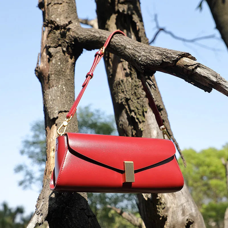 Milky white cowhide leather women's cross-body bag with pillow shape and cross-body strap.