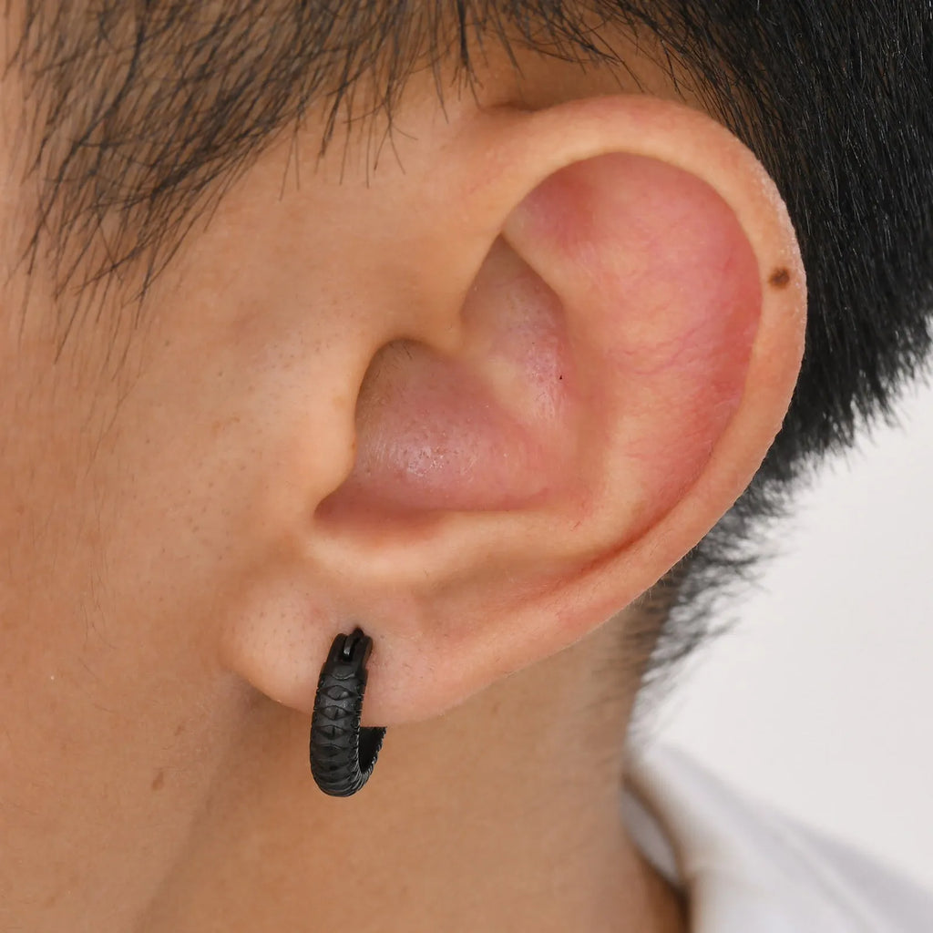 A pair of stainless steel earrings with a snake pattern design in a black finish.