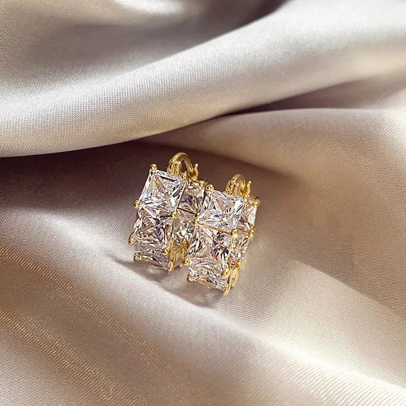 Geometric U-shaped gold ear ring with round black zircon stones
