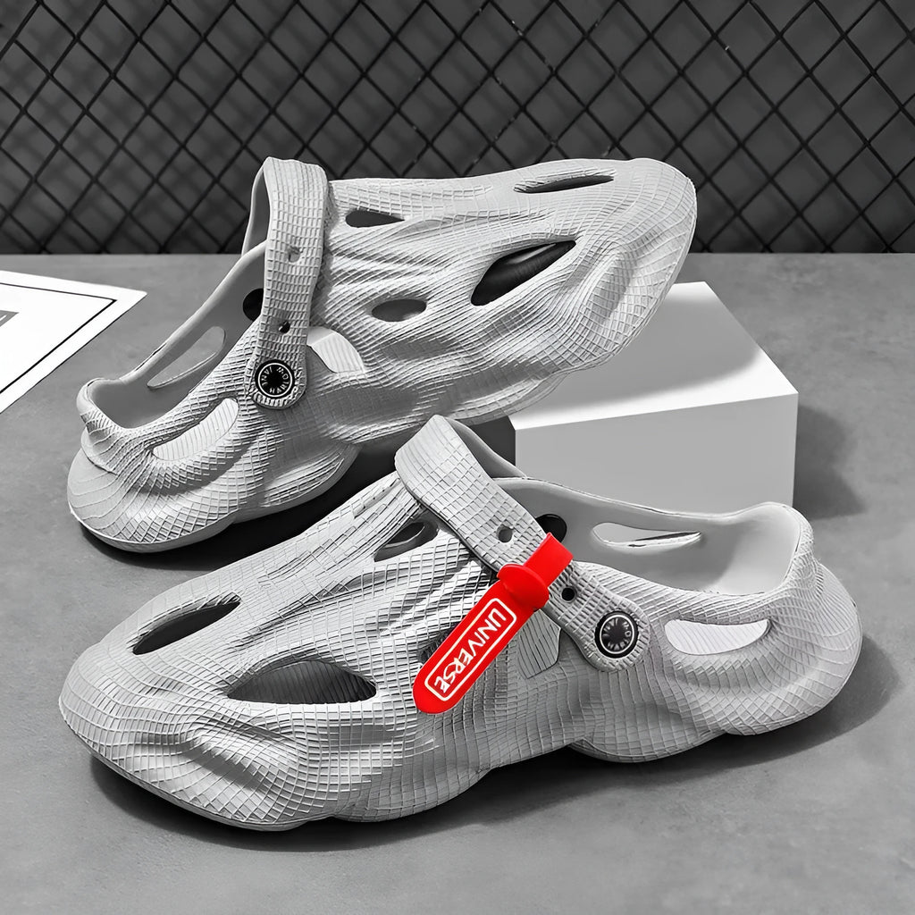 Grey closed-toe EVA coconut slippers on a beach background, showing frosted surface and injection moulded sole.